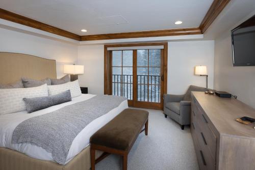 a bedroom with a bed and a desk and a television at Gravity Haus Vail in Vail