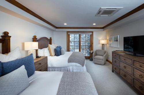 a bedroom with two beds and a flat screen tv at Gravity Haus Vail in Vail