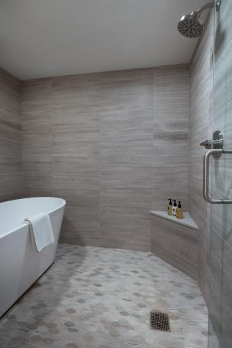 a bathroom with a white tub and a shower at Gravity Haus Vail in Vail