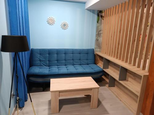 Sofá azul en la sala de estar con mesa en Hostal Platerías en León