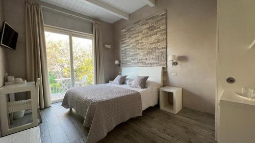 a bedroom with a bed and a large window at Borgo di Santa Barbara in Santa Domenica