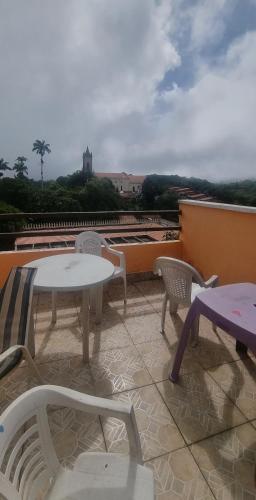 a patio with tables and chairs on a roof at Suites Solar dos Arcanjos Guaramiranga in Guaramiranga