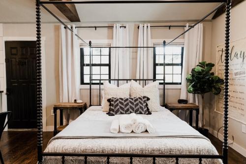 een slaapkamer met een hemelbed en handdoeken bij Spearfish Cottages in Spearfish