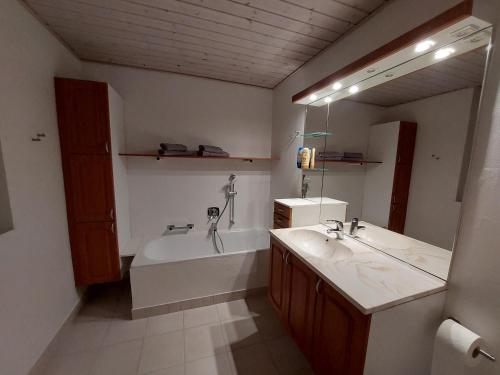 a bathroom with a tub and a sink and a mirror at Venos rooms in Hirtshals