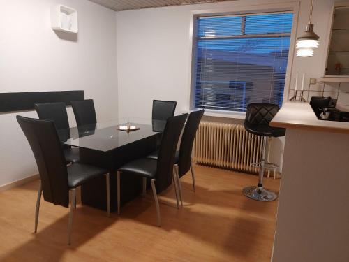 a dining room with a table and chairs and a window at Venos rooms in Hirtshals