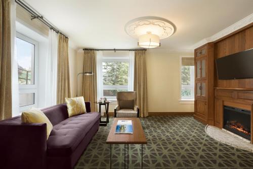 a living room with a couch and a fireplace at Fairmont Banff Springs in Banff