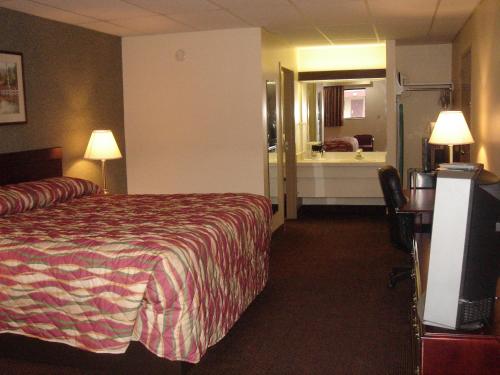 a hotel room with a bed and a bathroom at German Village Inn Motel in Columbus