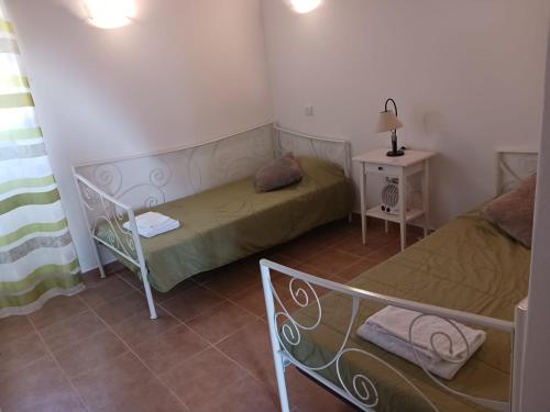 mały pokój z 2 łóżkami i stołem w obiekcie Quinta do Pinhal Novo w mieście Chabouco
