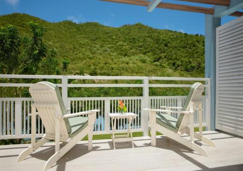 two chairs and a table on a porch with a view at St Martin Beach Resort & Spa in Anse Marcel 