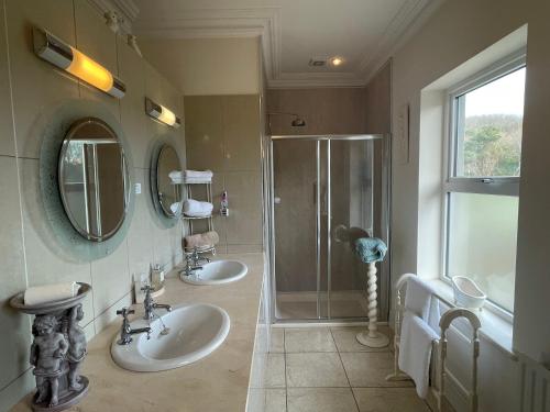 a bathroom with two sinks and a shower at Glendine Country House Wexford in Wexford