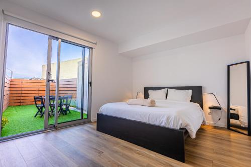 um quarto com uma cama e uma varanda com uma mesa em Mare Nostrum Apartment em Ponta Delgada