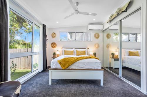 a bedroom with a bed and a large window at Kiki, 6 mins to Cairns and Airport, pet friendly in Cairns North