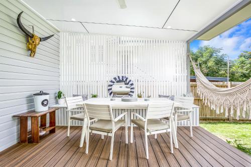 a white dining room with a white table and chairs at Kiki, 6 mins to Cairns and Airport, pet friendly in Cairns North