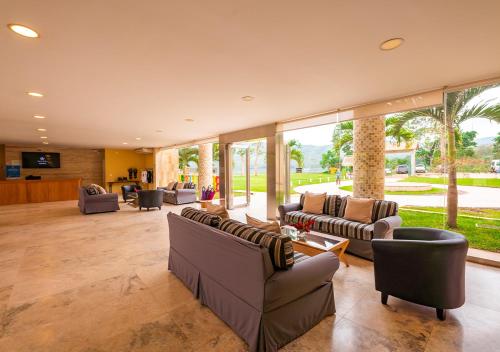 ein großes Wohnzimmer mit Sofas und Stühlen in der Unterkunft Bella Terra Laguna Azul Resort & Spa in Sauce