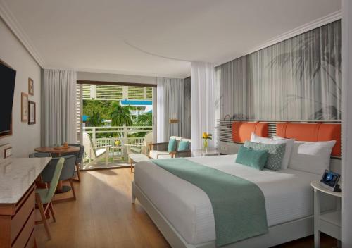 a bedroom with a large bed and a balcony at St Martin Beach Resort & Spa in Anse Marcel 