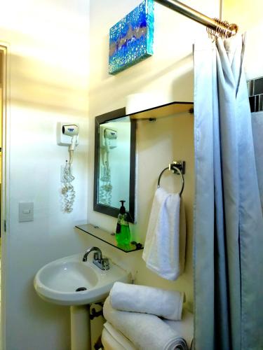 a bathroom with a sink and a mirror and towels at Apartamento Aquamarina, ideal trabajo/vacaciones in Cancún