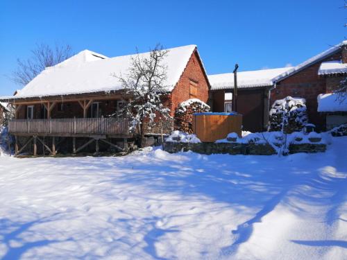 a house with snow on the ground in front of it at Borlova /Muntele Mic in Borlova