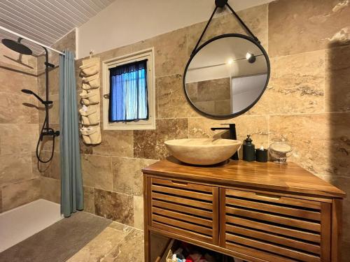 La salle de bains est pourvue d'un lavabo et d'un miroir. dans l'établissement Maison provençale au calme de la campagne avec Jacuzzi, à Aix-en-Provence