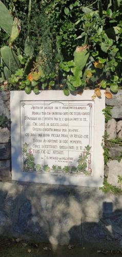 a sign in front of a garden with plants at La casa dei ciucciarielli in Furore
