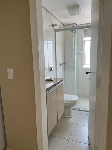 y baño con aseo, lavabo y ducha. en Apartamento no centro de Curitiba,bem localizado e confortável, en Curitiba