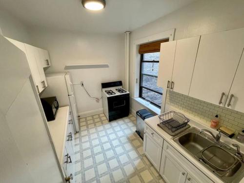 a small kitchen with a sink and a stove at Fantastic stay for 4 – Heart of Hoboken! in Hoboken