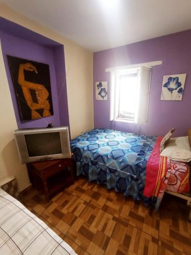 1 dormitorio con 1 cama y TV. en Hotel tanta Wasi, en Quito