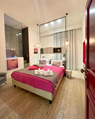 a bedroom with a large bed with two towels on it at XENIA LUXURY ROOMS in Reggio Calabria