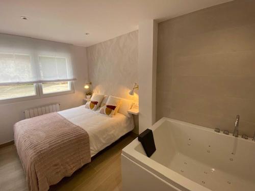 - une chambre avec un lit et une baignoire dans l'établissement Casa del Muelle COMILLAS, à Comillas