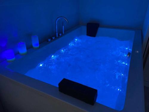 a bathroom with a blue tub with a fountain at Casa del Muelle COMILLAS in Comillas