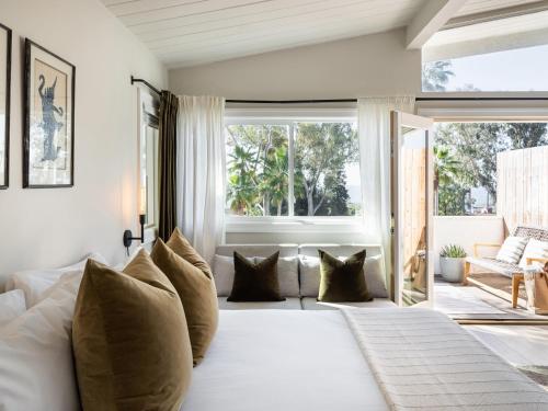 a bedroom with a large white bed with pillows at Laguna Beach Lodge in Laguna Beach
