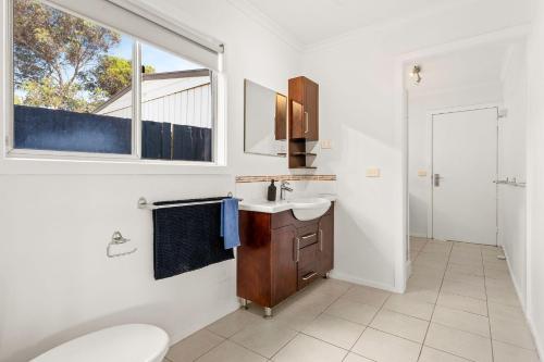 ein Bad mit einem Waschbecken, einem WC und einem Fenster in der Unterkunft Sea to Sunset View in Ventnor