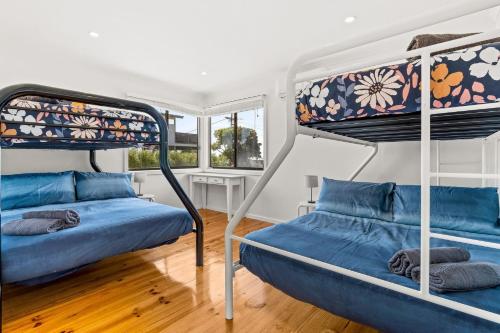 a bedroom with two bunk beds and a window at Sea to Sunset View in Ventnor