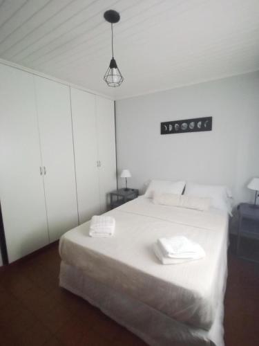 a bedroom with a white bed with two towels on it at La casita in Puerto Iguazú