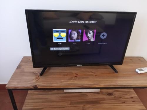 a flat screen tv sitting on a wooden table at La casita in Puerto Iguazú