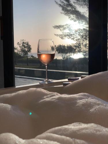 a glass of wine in a tub with a glass of wine at Lagoon Suites e Gastronomia in Laguna