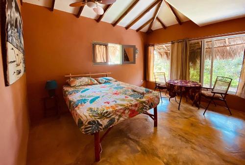 1 dormitorio con 1 cama, mesa y sillas en YES PAPA! Rooms at 100m from the beach!, en Las Galeras