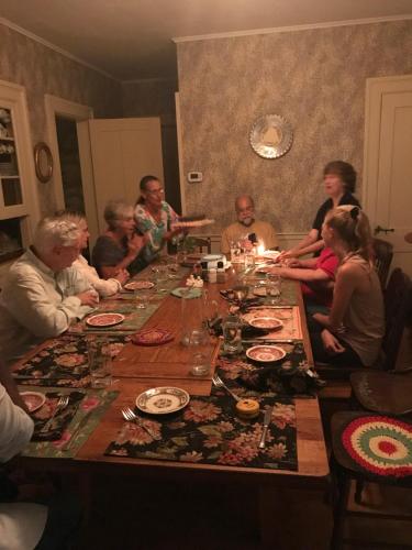 a group of people sitting around a long table at Sewall House Yoga Retreat in Island Falls