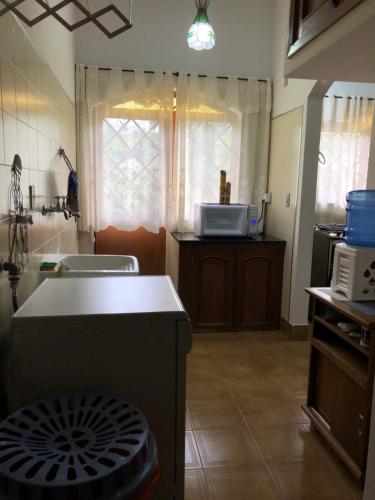 a kitchen with a table and a microwave in it at Recanto Arlecchino in Águas de Lindóia