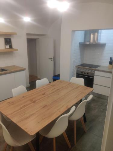 a kitchen with a wooden table and white chairs at Guesthouse Évora in Évora