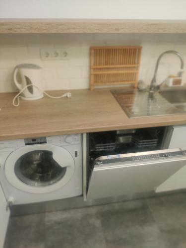 a kitchen with a washing machine under a counter at Guesthouse Évora in Évora