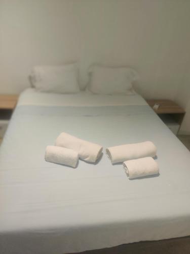 a white bed with two rolled towels on it at Guesthouse Évora in Évora