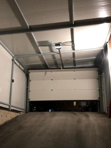 an empty parking garage with a large white garage door at Luxury apartment 1 Free Underground Secure Parking in Pazardzhik