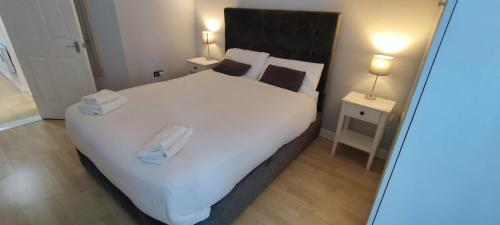een slaapkamer met een groot wit bed en 2 handdoeken bij Apartment in the heart of wexford town in Wexford