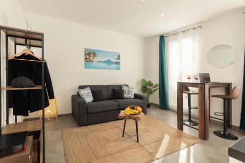un salon avec un canapé et une table dans l'établissement Sweet Aloha - Le Mourillon -Host, à Toulon