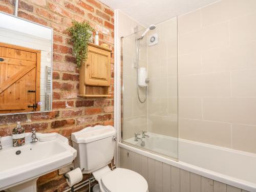 a bathroom with a toilet and a sink and a shower at The Dairy Barn in Fakenham