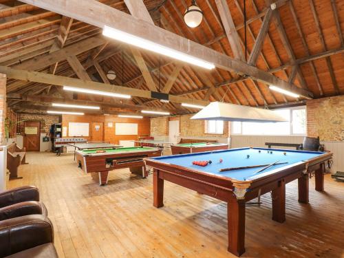a large room with pool tables in a building at The Dairy Barn in Fakenham