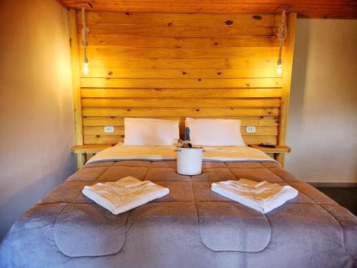 a bedroom with a bed with two towels on it at Suítes Sunset in Miguel Pereira