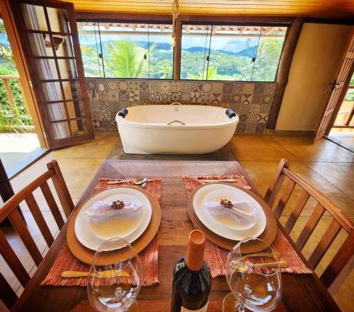 a table with two plates and a tub in a room at Suítes Sunset in Miguel Pereira
