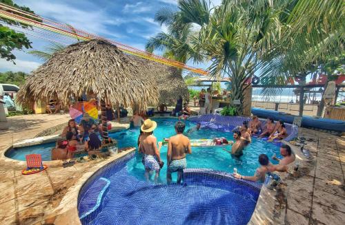 um grupo de pessoas numa piscina num resort em The Driftwood Surfer Beachfront Hostel / Restaurant / Bar, El Paredon em El Paredón Buena Vista
