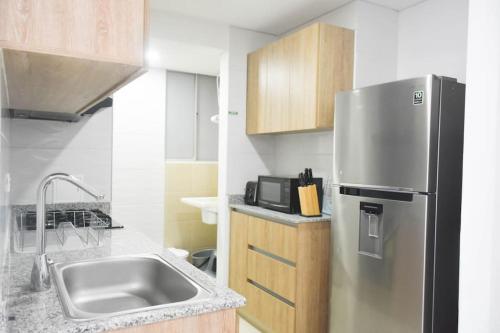 a kitchen with a stainless steel refrigerator and a sink at Condominio, Bello Horizonte Plaza, Santa Marta. in Santa Marta